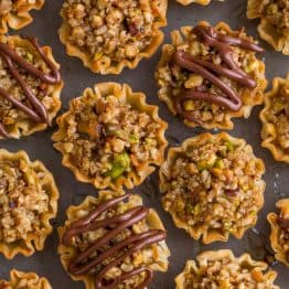 Mini Baklava Cups taste like authentic baklava but easier! The honey and lemon syrup make these baklava cups completely irresistible. A make-ahead recipe! | natashaskitchen.com