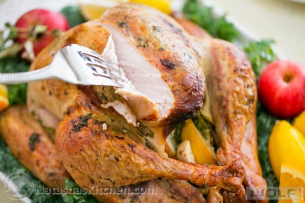 Slicing into juicy turkey breast on a baked turkey